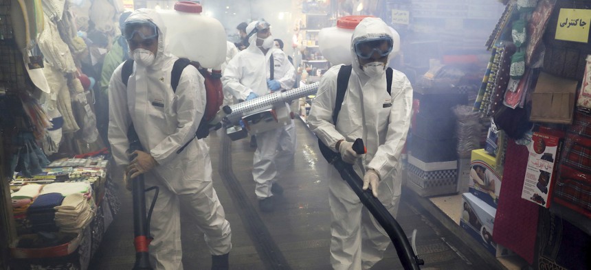 Firefighters disinfect a traditional shopping center to help prevent the spread of the new coronavirus in northern Tehran, Iran, Friday, March, 6, 2020.